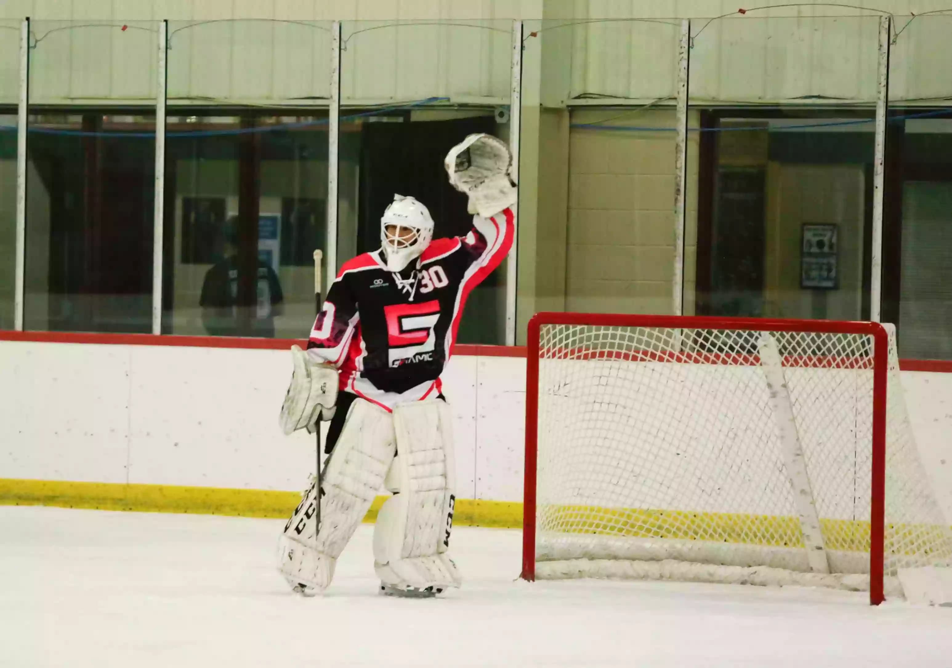 Sublimated ice hockey goalie jersey with laced neckline, black, red, and white design