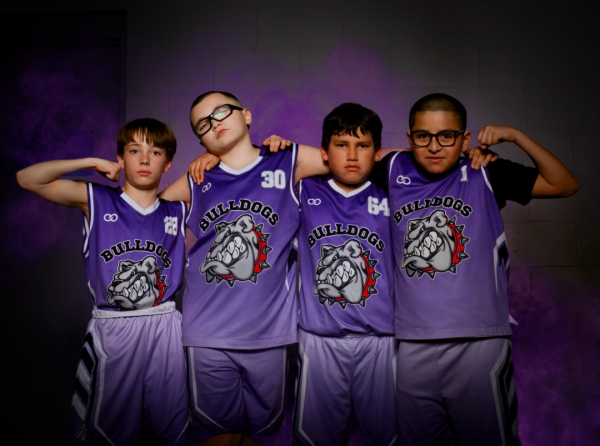 Youth basketball team wearing matching purple Bulldogs uniforms posing together.