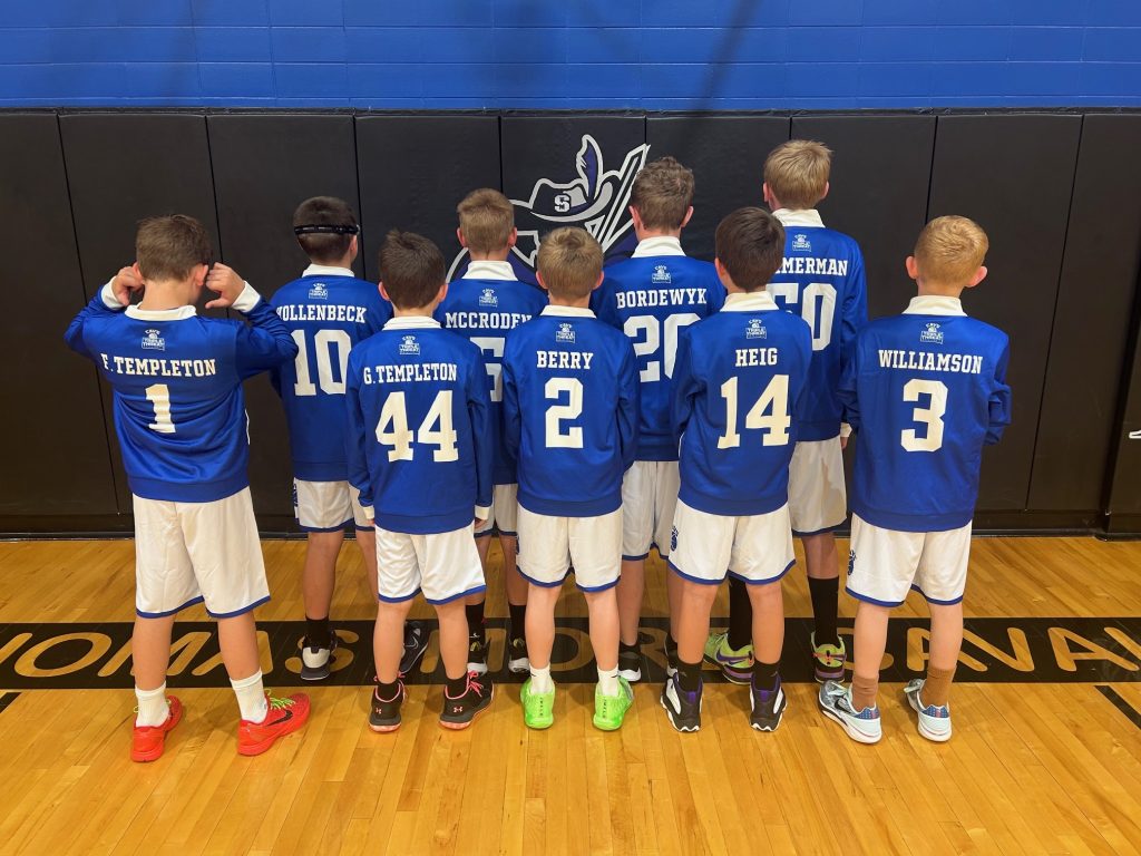 Youth basketball team wearing matching custom jerseys with consistent names and numbers